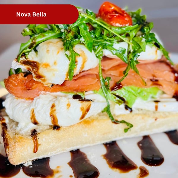 Nova Bella breakfast dish with smoked salmon, burrata, arugula, and cherry tomatoes on a waffle.