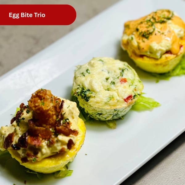 Three different egg bites, one with bacon, one with vegetables, and one with sauce, on a white plate.
