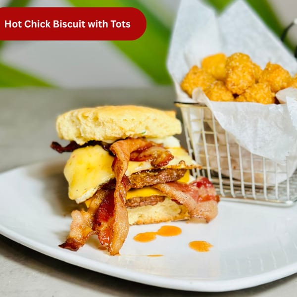 A Hot Chick Biscuit with bacon, egg, and cheese, served with a side of crispy tater tots.