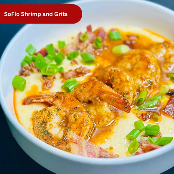 A bowl of Mom's Kitchen SoFlo Shrimp and Grits, garnished with bacon and green onions.