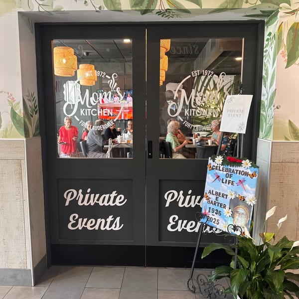 Mom's Kitchen entrance with "Private Events" on doors, showing customers inside and a "Celebration of Life" sign.